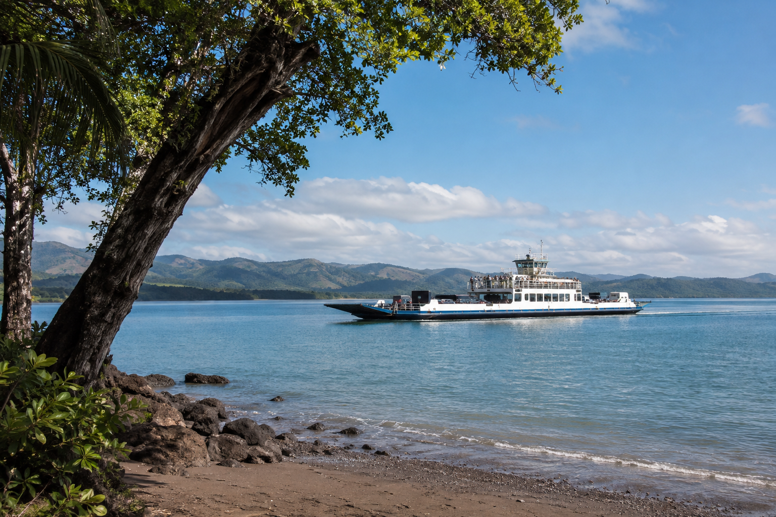A vehicle-and-passenger ferry crosses calm water with low green hills in the distance.