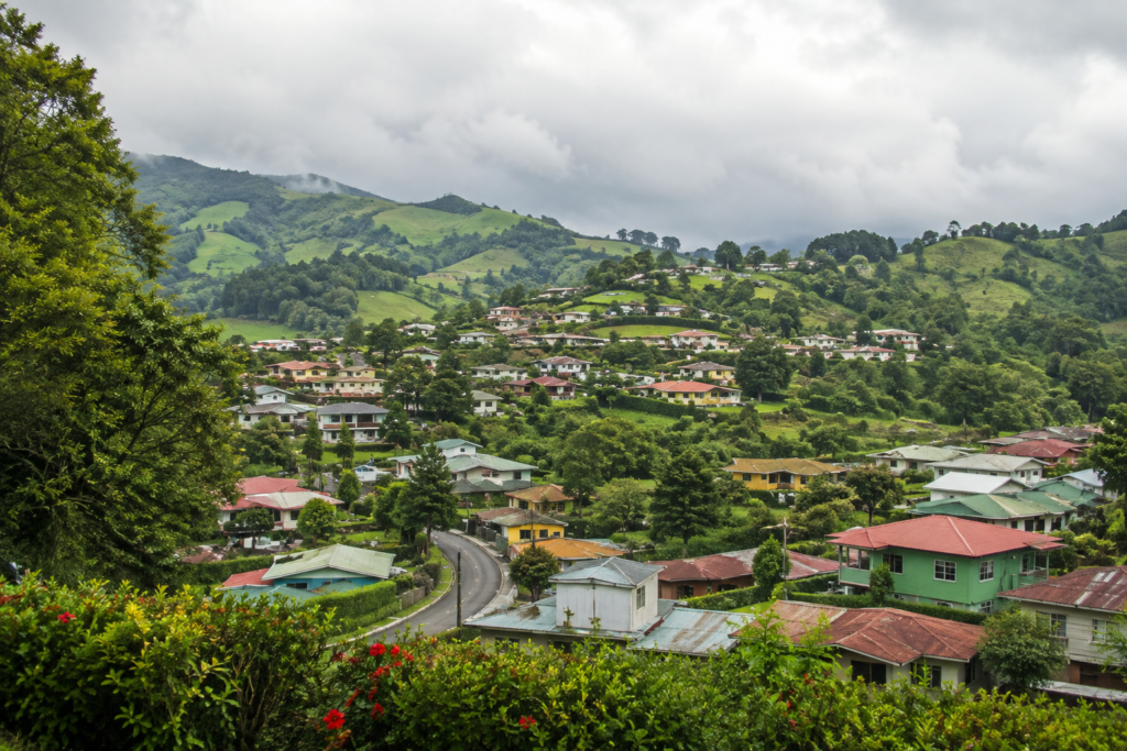 Low-rise homes cluster among rolling green hills.