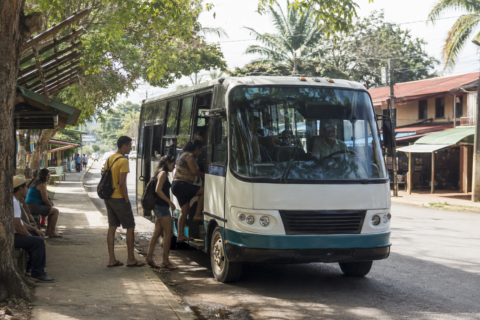 Passengers board a bus beside a shaded street with low-rise buildings.
