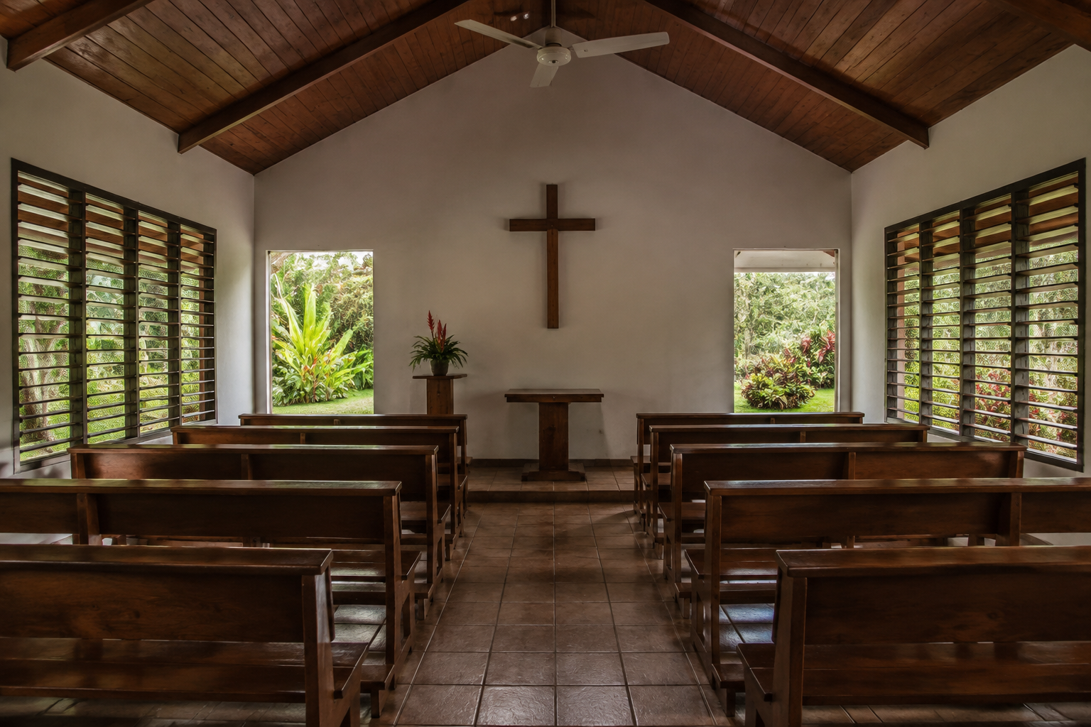 Quiet chapel interior with rows of wooden seating
