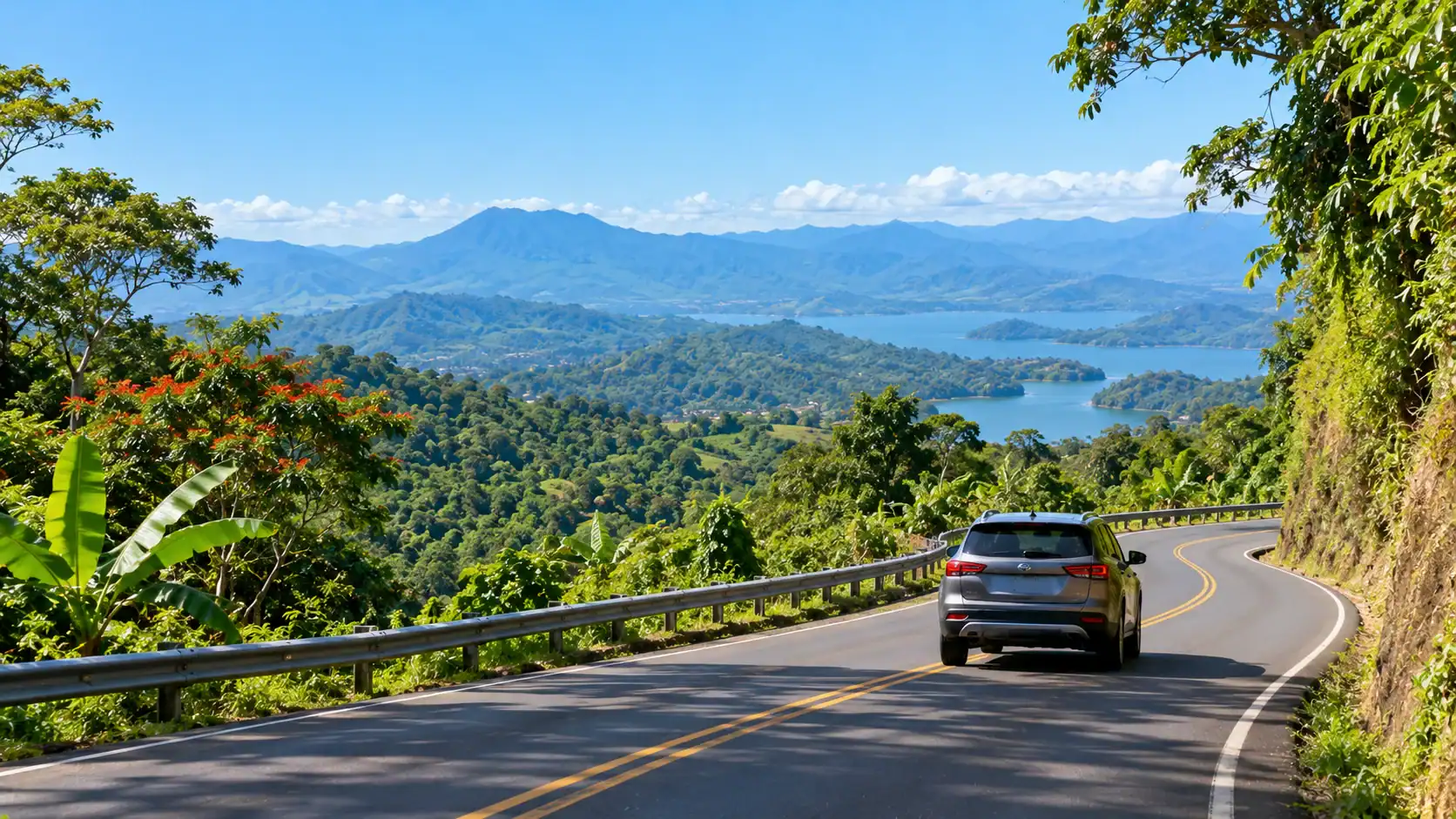 A car driving on a winding paved road through green mountains in Costa Rica
