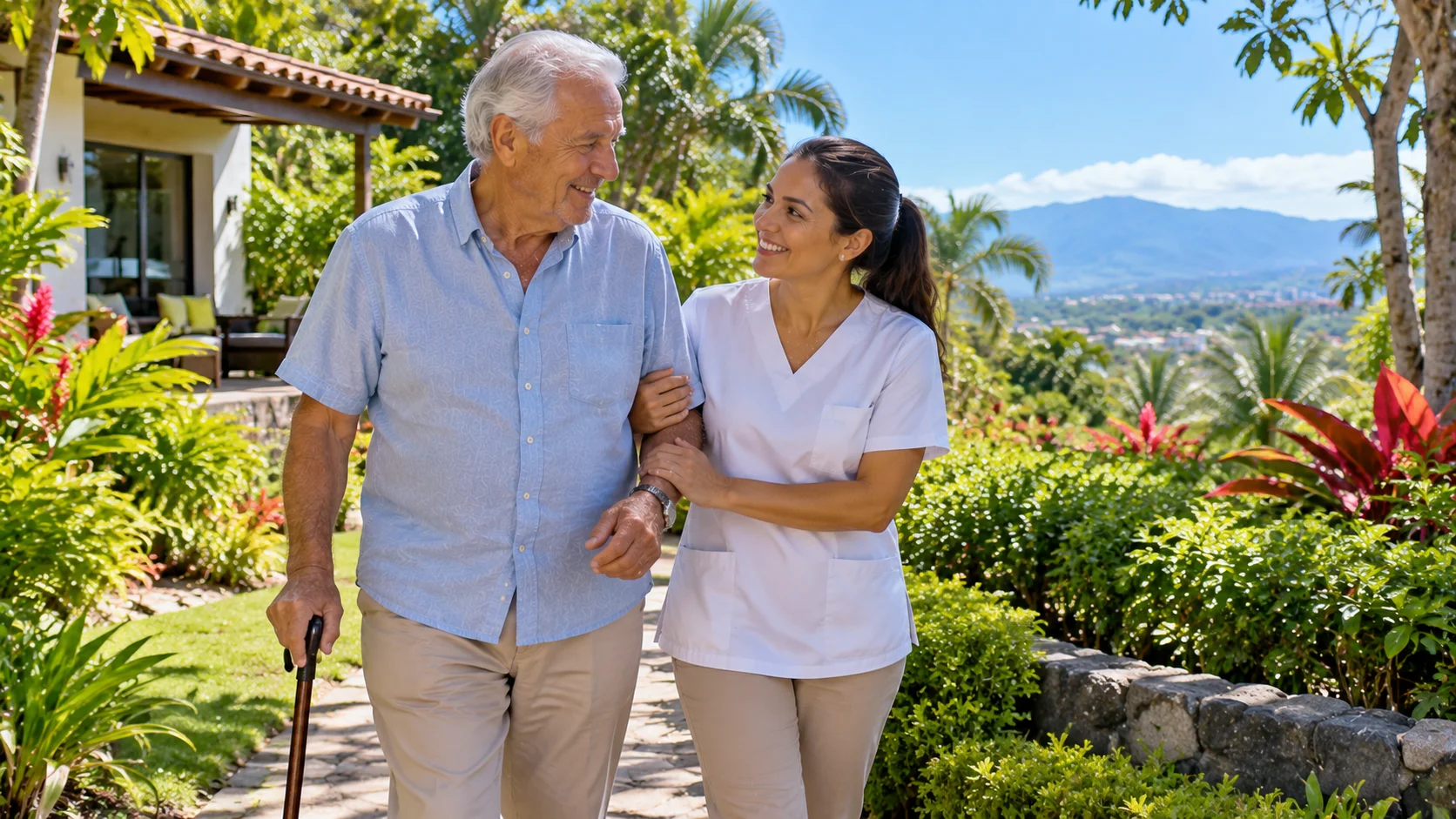 A caregiver walking arm in arm with an elderly man through a garden in Costa Rica