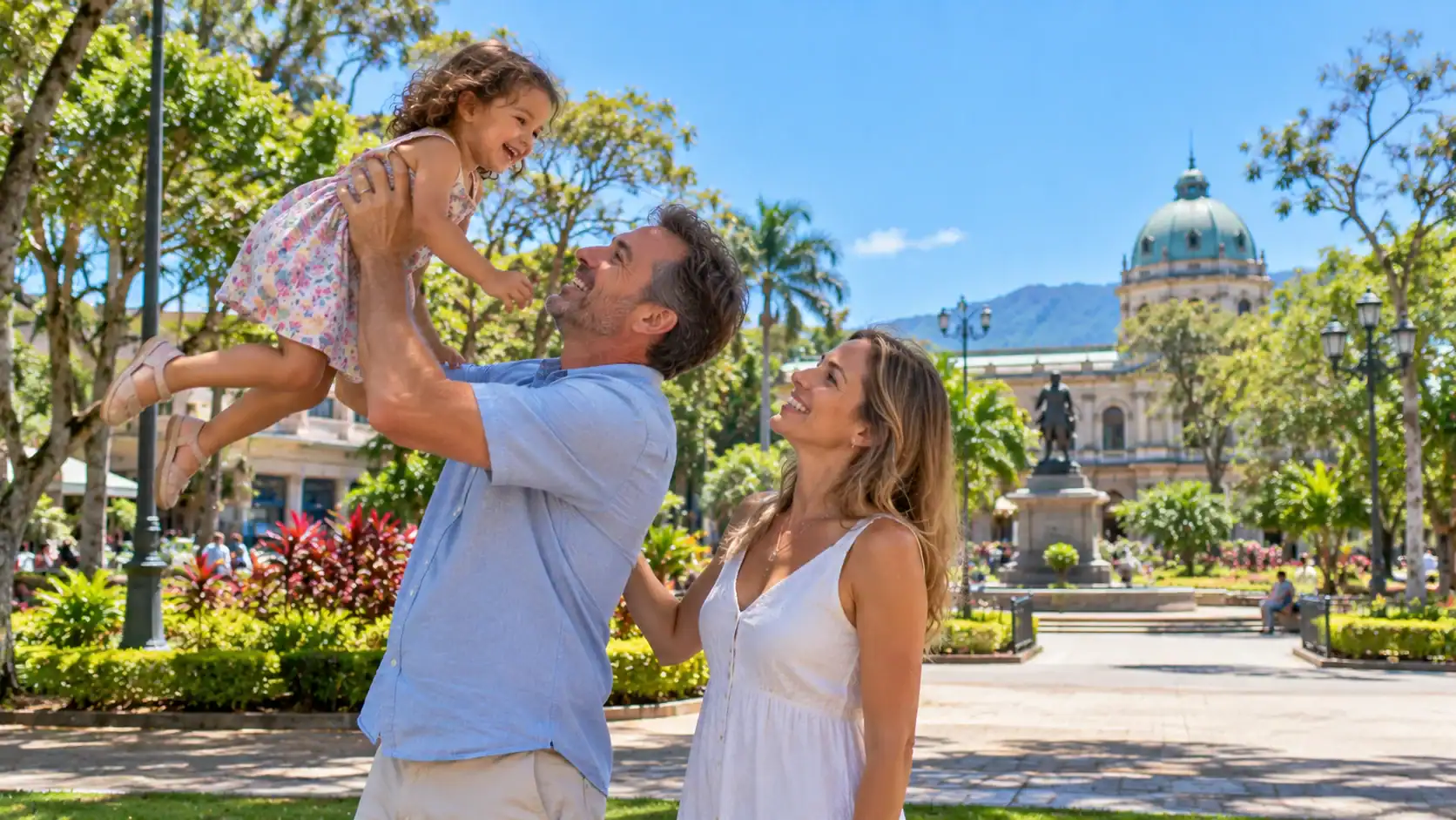 A foreign couple playing with their young child in a park in San José