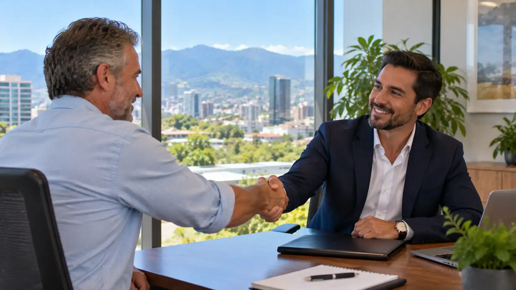 A man shaking hands with a new employer in a modern office in San José