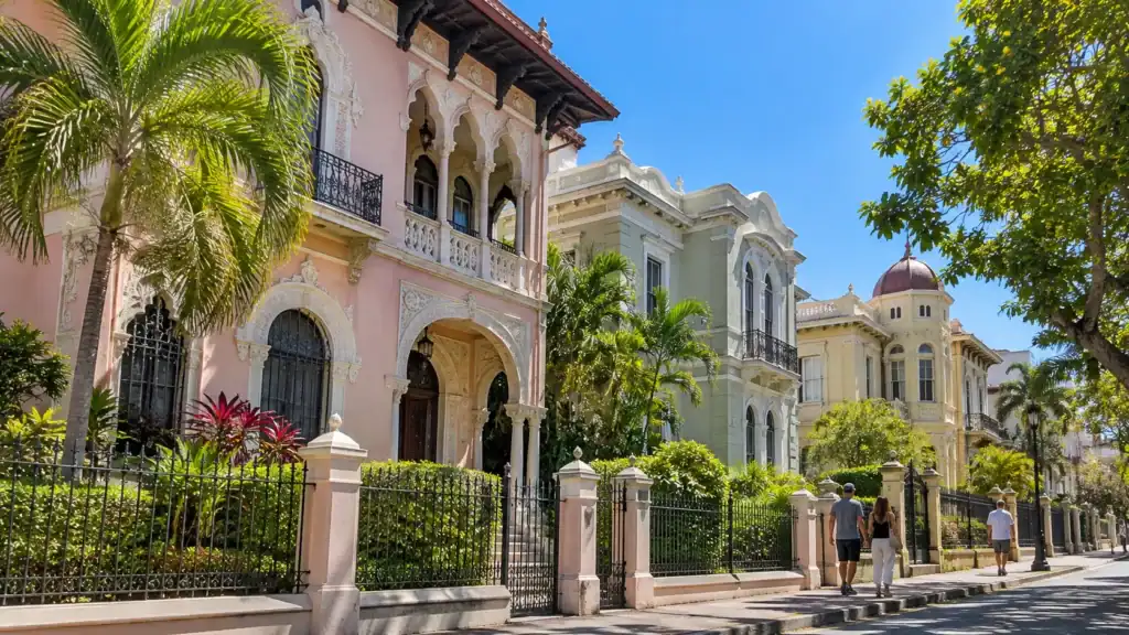 Pastel early-20th-century mansions with ornate balconies and arched windows on a sunny street in Barrio Amón, San José