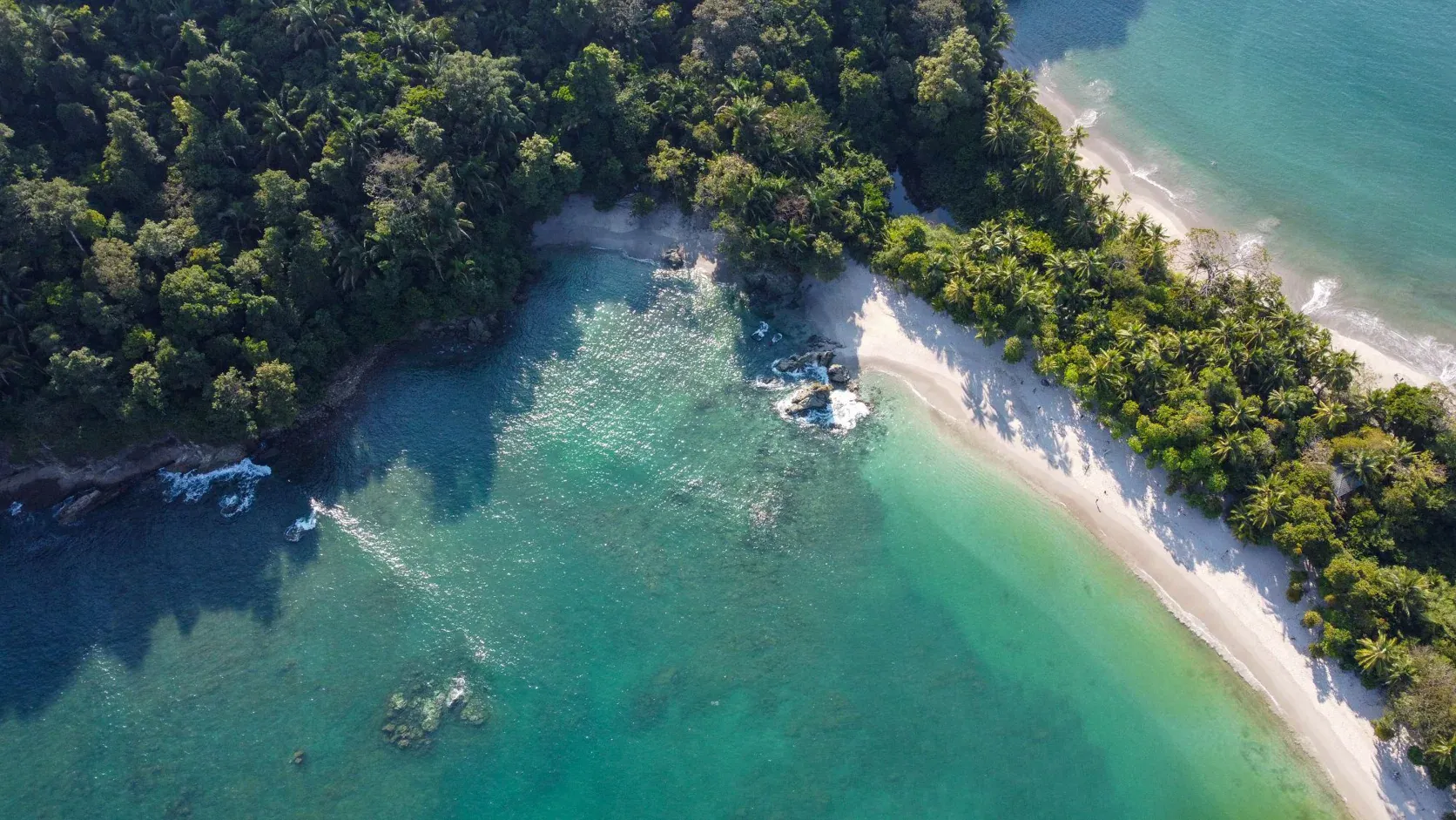 Aerial view of a white-sand beach and turquoise bay in Manuel Antonio, Costa Rica