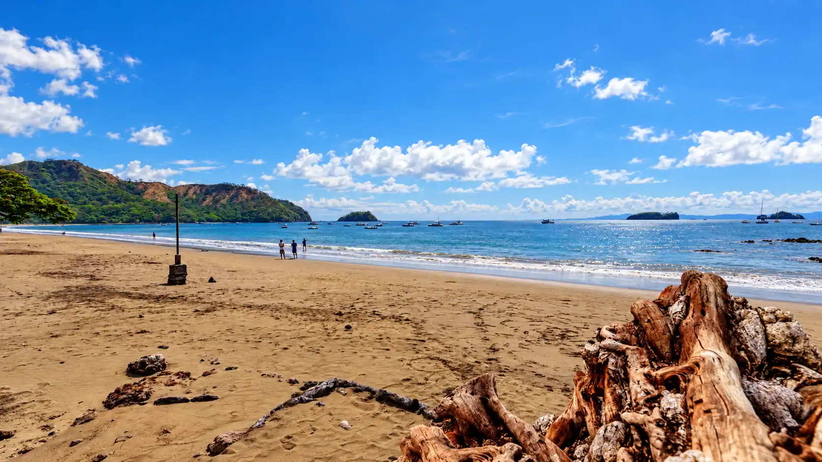 Playas del Coco beach in Guanacaste, Costa Rica, with green hills and blue sky