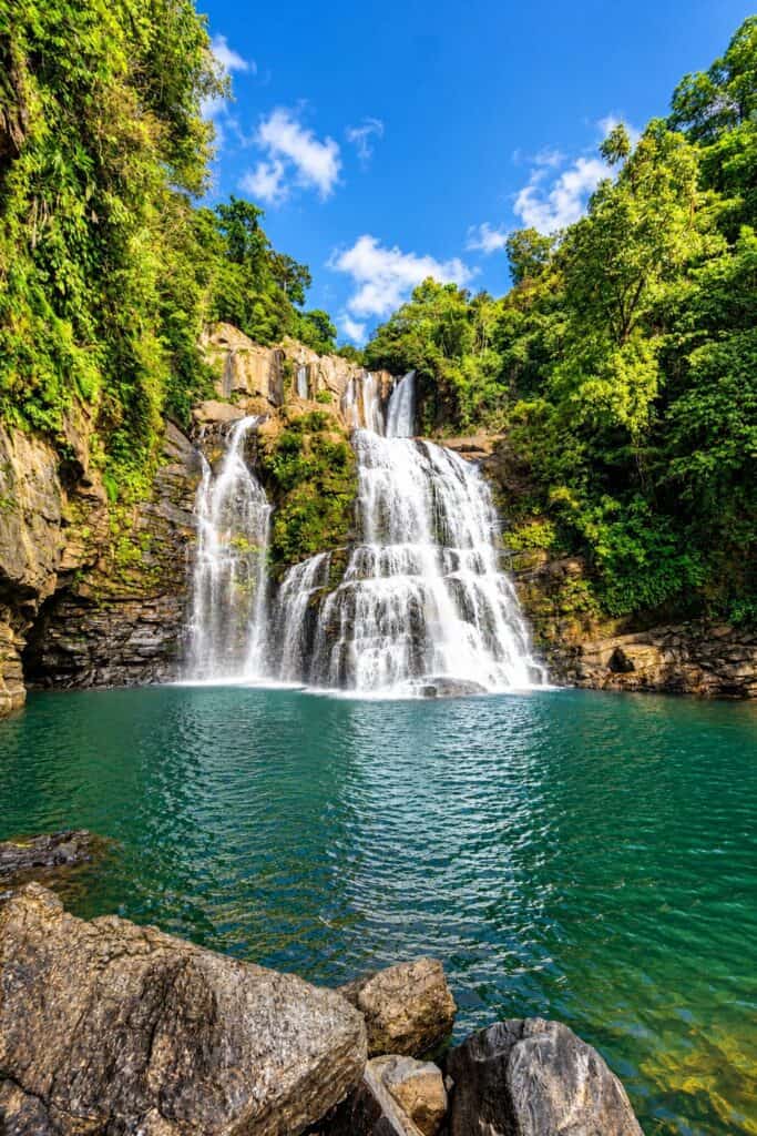 Nauyaca Waterfalls and their swimming pool under a blue sky in southern Costa Rica
