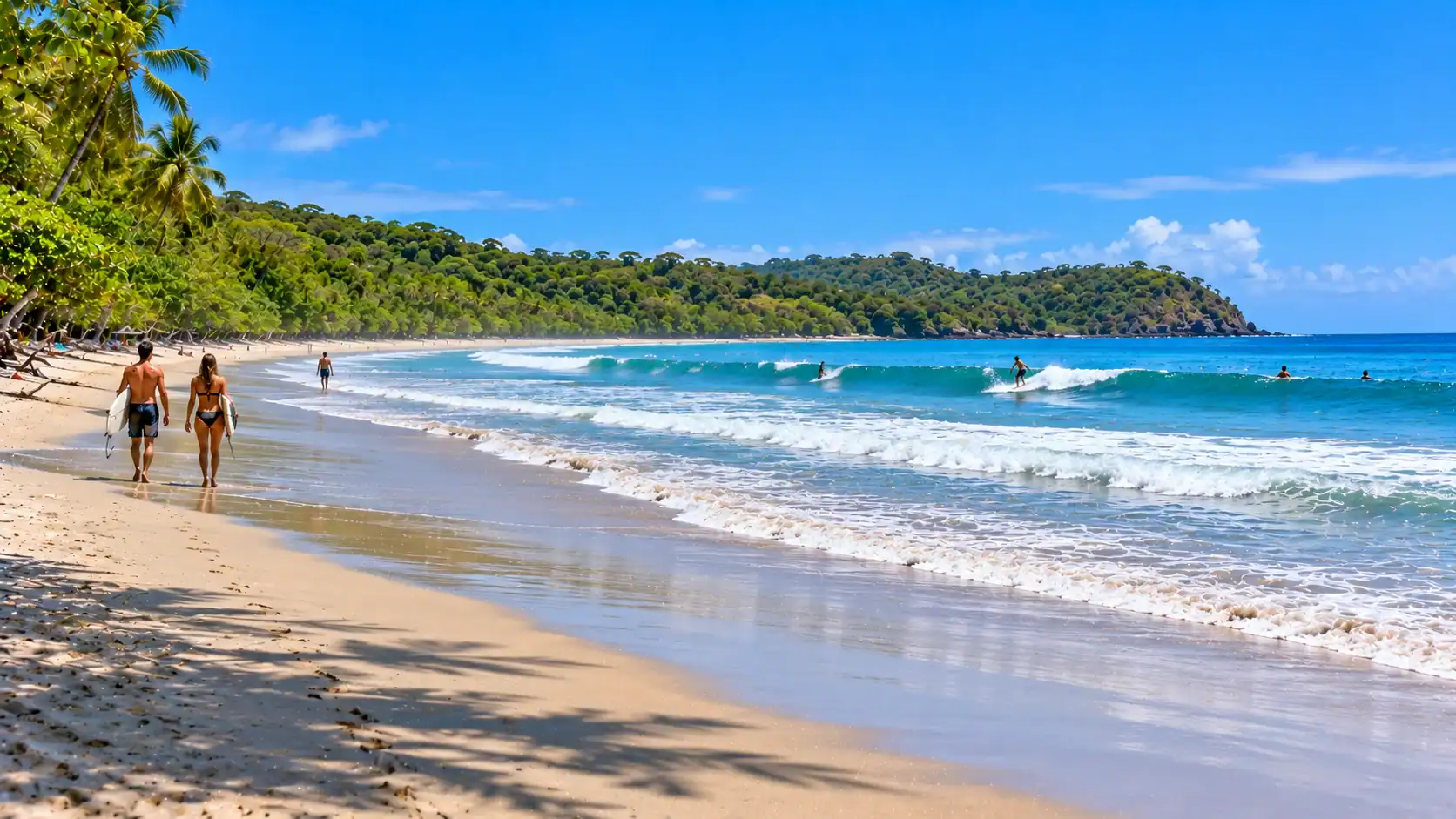 Surfers walking along the jungle-backed beach at Playa Guiones near Nosara, Guanacaste