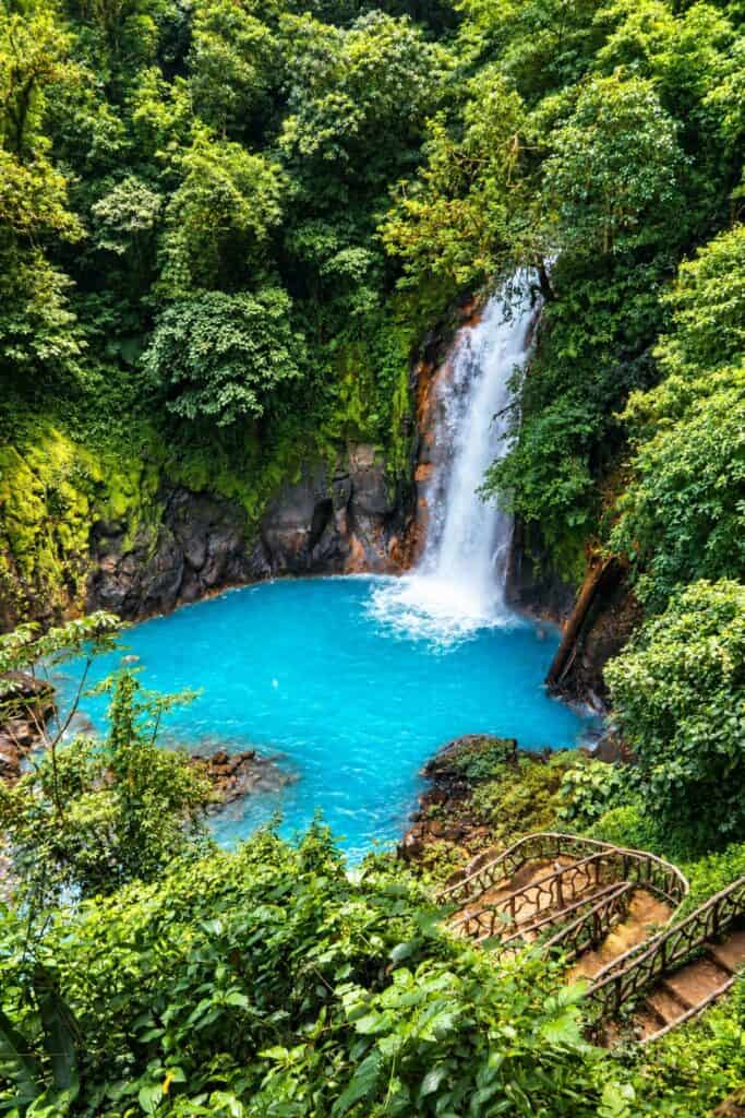 Río Celeste waterfall falling into a sky-blue pool in Tenorio Volcano National Park, Costa Rica